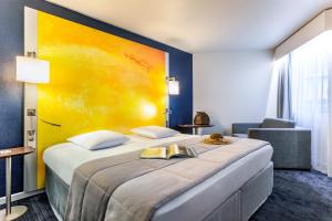 una habitación de hotel con una cama con una pintura en la pared en Mercure Rouen Centre Cathédrale, en Rouen 137 fotos más