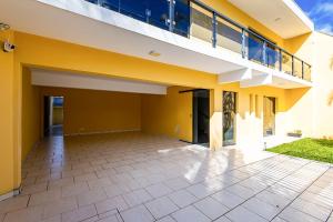 a large yellow house with a large patio at Sottam Hostel in Curitiba