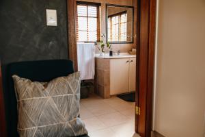 a bathroom with a sink and a chair in a room at Cwebile Guesthouse in Winterton +116 photos