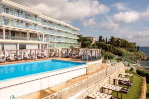 a hotel with a swimming pool and a building at Alyssium in Benitses