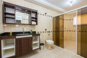 a bathroom with a shower and a sink and a toilet at Sottam Hostel in Curitiba
