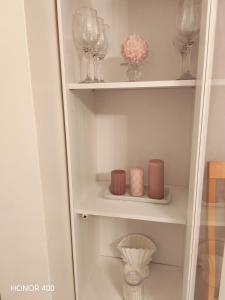 a white cabinet with glasses and vases on it at Light Home in Sodankylä