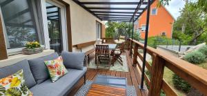 a porch with a couch and a table on a balcony at Bike & Chill Apartment in Balatonfüred