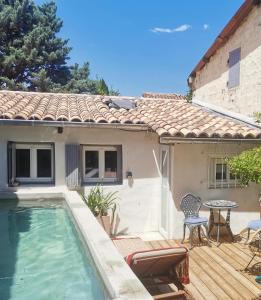 a house with a pool and a table and chairs at Casa d'Olivier chambre d'hôtes in Arles