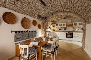 eine Küche und ein Esszimmer mit Tisch und Stühlen in der Unterkunft Naki in Bosa