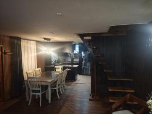 a dining room with a table and chairs and a staircase at Mary y Luis in Coihaique +18 photos
