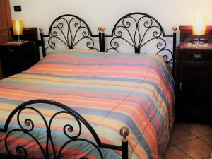 ein Bett mit einer bunten gestreiften Bettdecke in einem Schlafzimmer in der Unterkunft Appartamento Danilla in Maratello