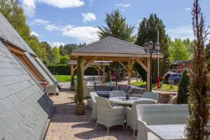a gazebo with chairs and tables in a patio at 20 The Green, Lilliardsedge in Jedburgh