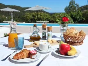 a table with a breakfast of croissants bread and fruit at Hotel Rural Can Maries in Puerto de San Miguel