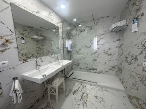 a white bathroom with a sink and a mirror at Hotel Rural Can Maries in Puerto de San Miguel +68 photos