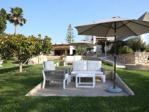 a patio with two chairs and an umbrella at Hotel Rural Can Maries in Puerto de San Miguel