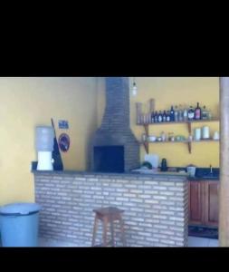 a kitchen with a brick bar with a stool in front of it at Hospedagem da Paty in Ilhéus