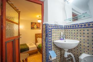 a bathroom with a sink and a bedroom at Riad Iline fes in Fez