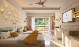 ein Wohnzimmer mit zwei Betten und einem Kamin in der Unterkunft Iberostar Waves Tucan - All Inclusive in Playa del Carmen