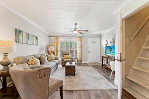 a living room with a couch and a ceiling fan at The Poolside Cottage -Wifi Pool in Jacksonville