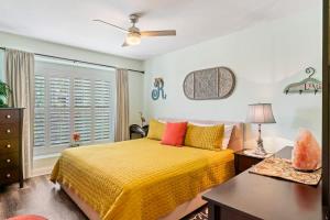 a bedroom with a yellow bed and a window at The Poolside Cottage -Wifi Pool in Jacksonville