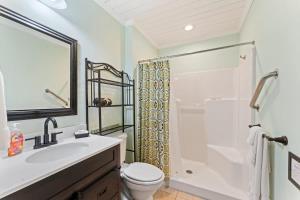 a bathroom with a sink and a toilet and a shower at The Poolside Cottage -Wifi Pool in Jacksonville