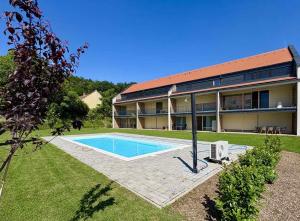 a house with a swimming pool in the yard at Vinopool Suites Badacsony in Badacsonytomaj
