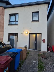 a white house with a door and some trash at Bellfield Views in Dundee