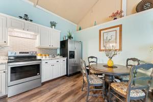 a kitchen with white cabinets and a table with chairs at The Poolside Studio - Lounge Pool Wifi in Jacksonville