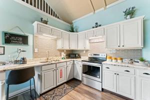 a kitchen with white cabinets and a stove top oven at The Poolside Studio - Lounge Pool Wifi in Jacksonville