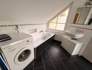 a bathroom with a washing machine and a sink at Ferienwohnung am Holmmoor in Quickborn +6 photos