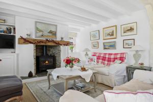 a living room with a couch and a fireplace at Dart View Cottage - A Stunning Riverside Escape in the Heart of South Devon in Dittisham