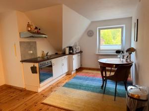 a kitchen with a table and a small kitchen with a window at Ferienwohnung am Holmmoor in Quickborn