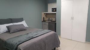 a bedroom with a large bed and a kitchen at MERK Guest House in Piet Retief