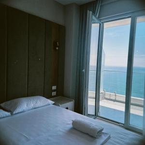 a bedroom with a bed with a view of the ocean at DreamStay Lezha Apartments - Ilyonis Residence in Lezhë