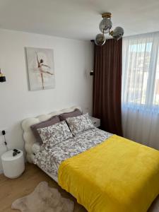 a bedroom with a bed with a yellow blanket at Paradise Relax in Zalău