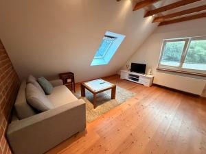 a living room with a couch and a tv at Ferienwohnung am Holmmoor in Quickborn
