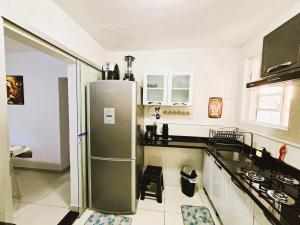 a kitchen with a stainless steel refrigerator in it at Apto Térreo p/6 Pessoas Próx Aeroporto e Shopping in Várzea Grande
