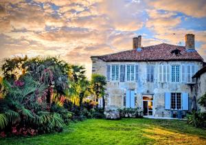 an old stone house with a yard with palm trees at Château Arche d'Aure in Vicq-dʼAuribat +15 photos