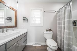 a white bathroom with a toilet and a sink at The Berlin Guesthouse in Millersburg +35 photos
