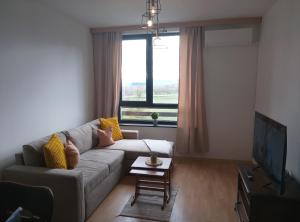 a living room with a couch and a tv at Mountain Nest Pirin in Razlog