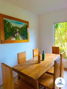 a wooden dining room table with chairs and a painting at Cabaña Villa July in Moñitos