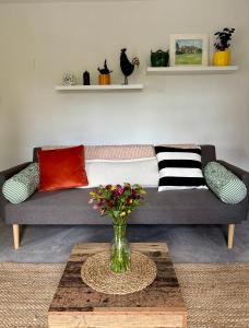 a living room with a couch and a vase with flowers at Stylish Countryside Loft near Silverstone-Bicester in Buckingham