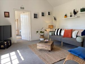 a living room with a couch and a tv at Stylish Countryside Loft near Silverstone-Bicester in Buckingham +34 photos