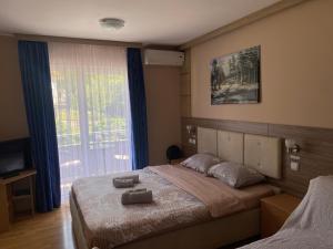 a bedroom with a bed with two towels on it at KONAK ViLA MIRKOVIĆ in Soko Banja