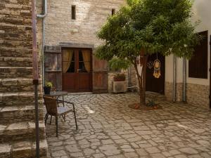 a patio with a table and a tree in front of a building at Four Stories Lefkara in Pano Lefkara
