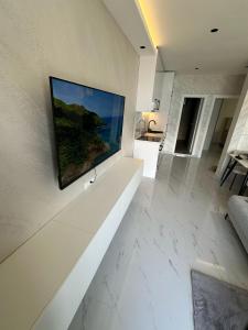 a living room with a television on a wall at Bellanti2 in Igalo +21 photos
