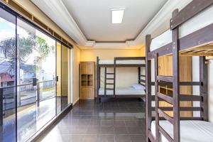 a room with bunk beds and a balcony at Sottam Hostel in Curitiba