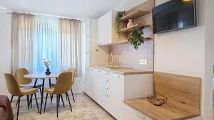a kitchen and dining room with a table and chairs at Apartments Grozdana in Baška