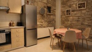 a kitchen with a table and a stainless steel refrigerator at Four Stories Lefkara in Pano Lefkara