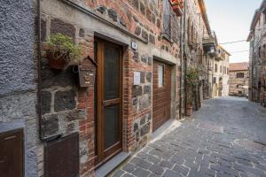 an alley with a brick building and a door at La Casetta dei Forni in Radicofani