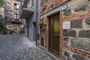 an alley with a door on a brick building at La Casetta dei Forni in Radicofani