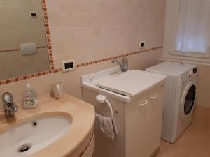 a bathroom with a washing machine and a sink at la casa rosa in Breguzzo