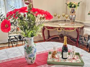 a table with a bottle of champagne and a vase with flowers at Château Arche d'Aure in Vicq-dʼAuribat