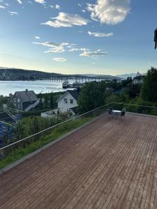 a deck with a bench and a view of the water at Tromso Panorama in Tromsø